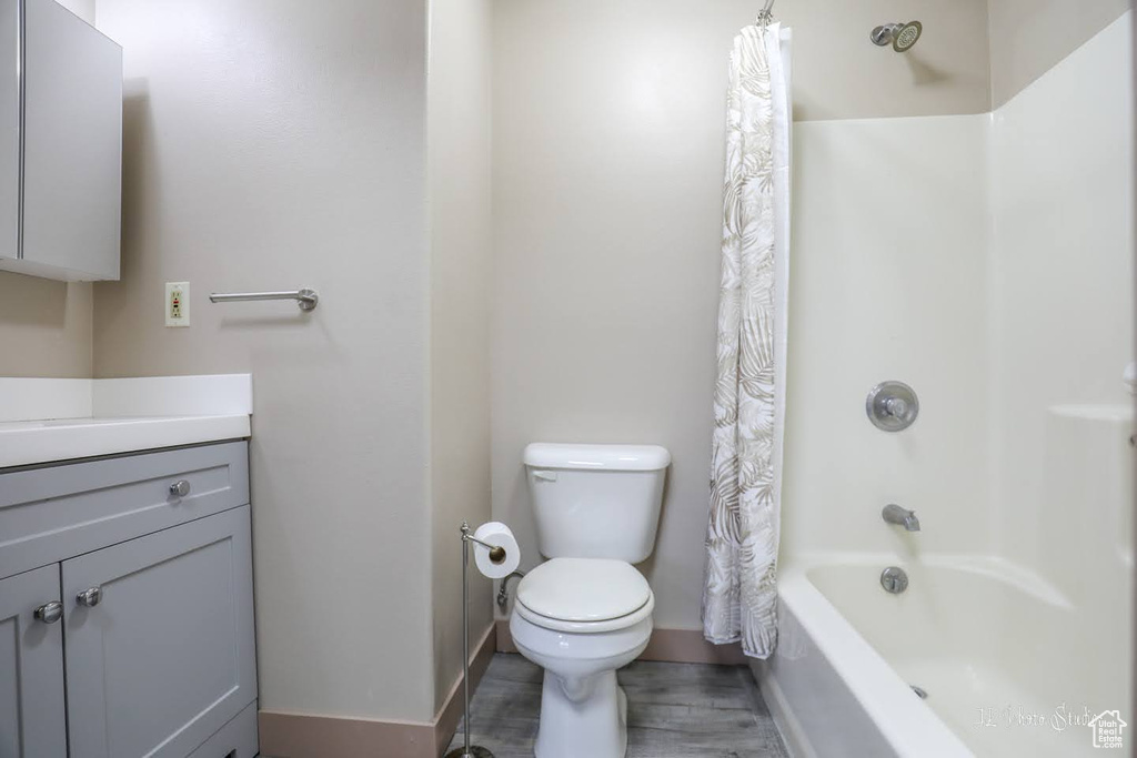 Full bathroom featuring vanity, shower / bath combo, and toilet