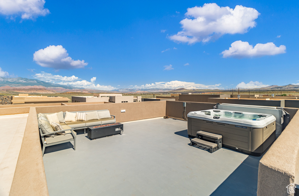 View of terrace with a hot tub and a mountain view