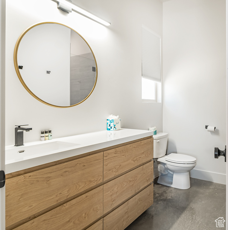 Bathroom with vanity, concrete floors, and toilet