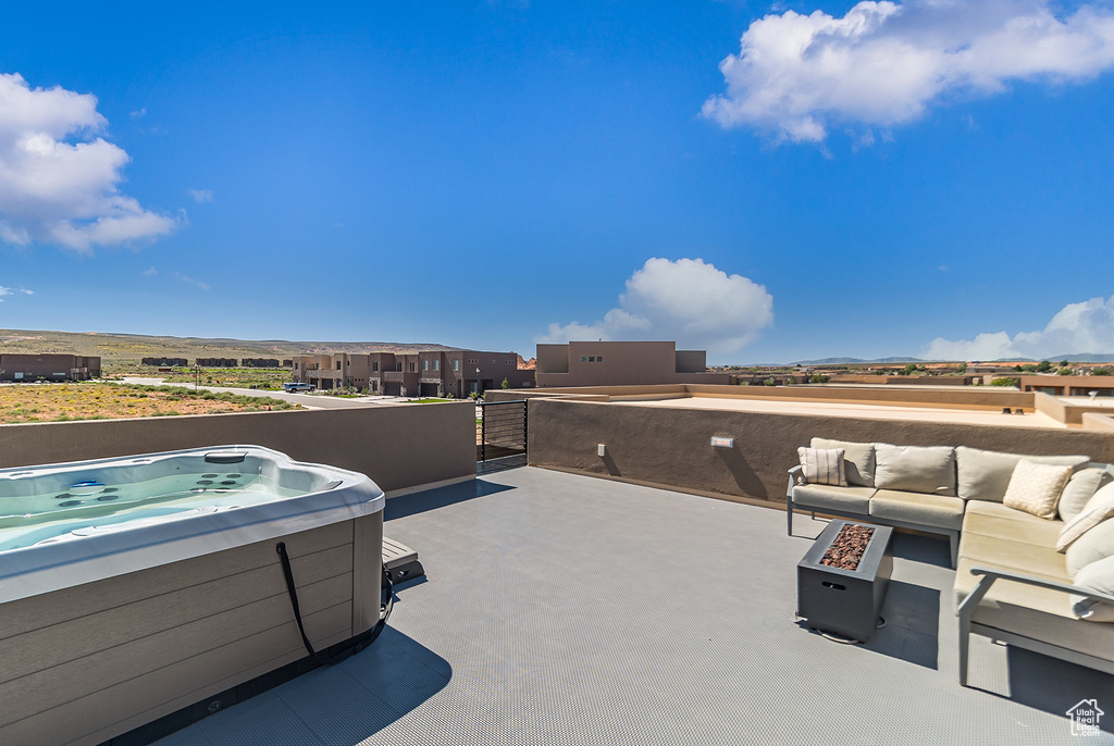 View of terrace with a hot tub, an outdoor hangout area, and a balcony