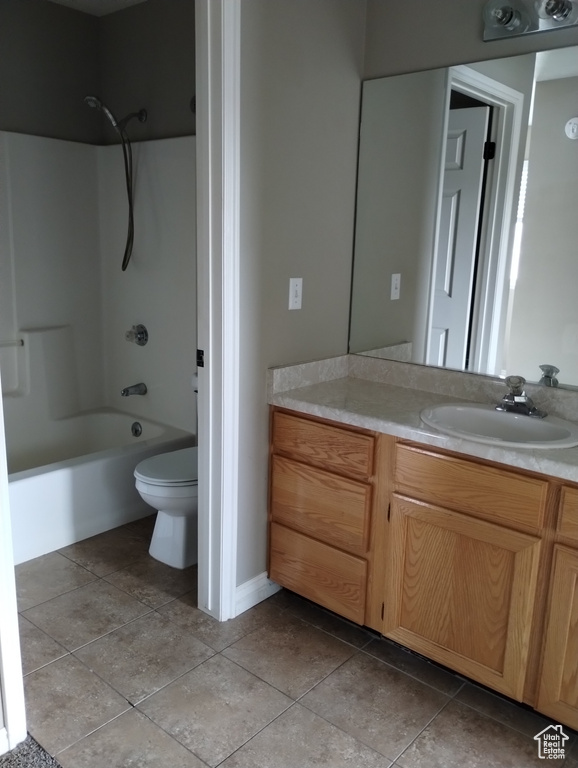 Full bathroom featuring vanity, toilet, tub / shower combination, and tile flooring