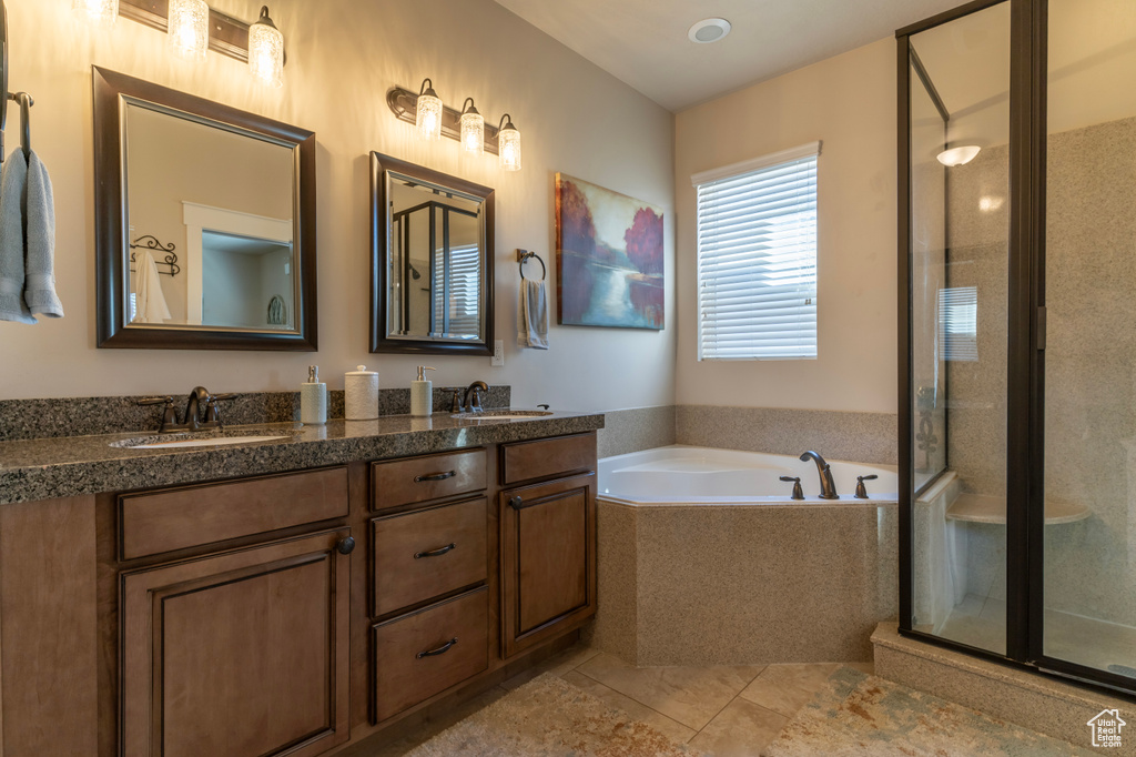Bathroom with shower with separate bathtub, double vanity, and tile flooring