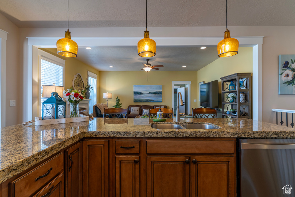 Kitchen featuring hanging light fixtures, sink, ceiling fan, and stainless steel dishwasher