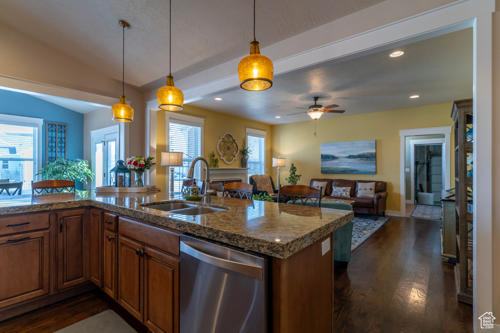 Kitchen with hanging light fixtures, dishwasher, ceiling fan, and sink