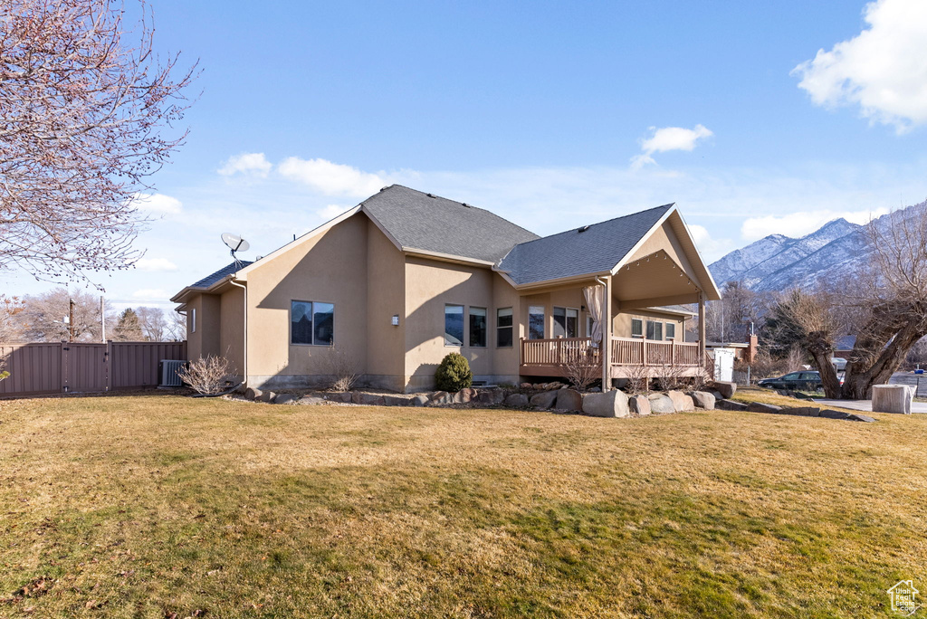 View of front of home featuring a front yard and a deck with mountain view