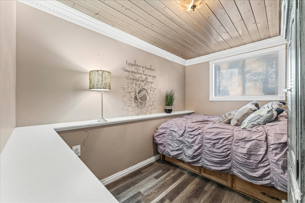 Bedroom featuring dark hardwood / wood-style flooring, wooden ceiling, and ornamental molding