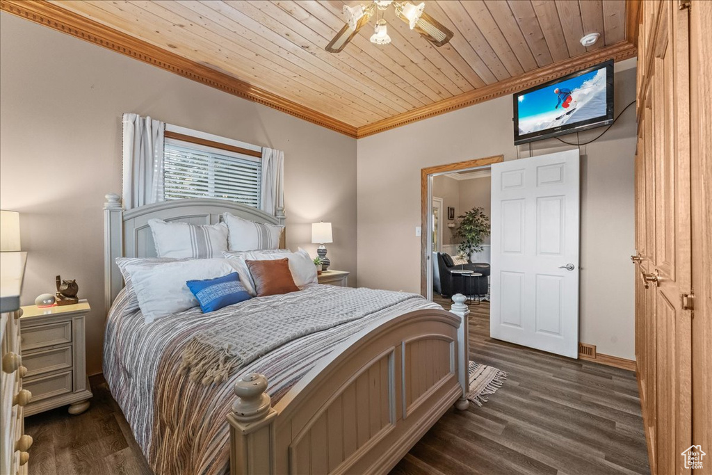 Bedroom featuring dark wood-type flooring, ceiling fan, wooden ceiling, and ornamental molding