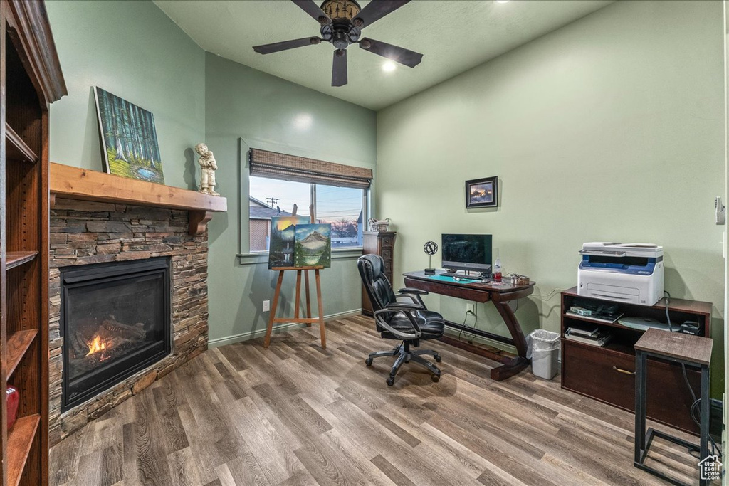 Office space with a fireplace, hardwood / wood-style floors, and ceiling fan