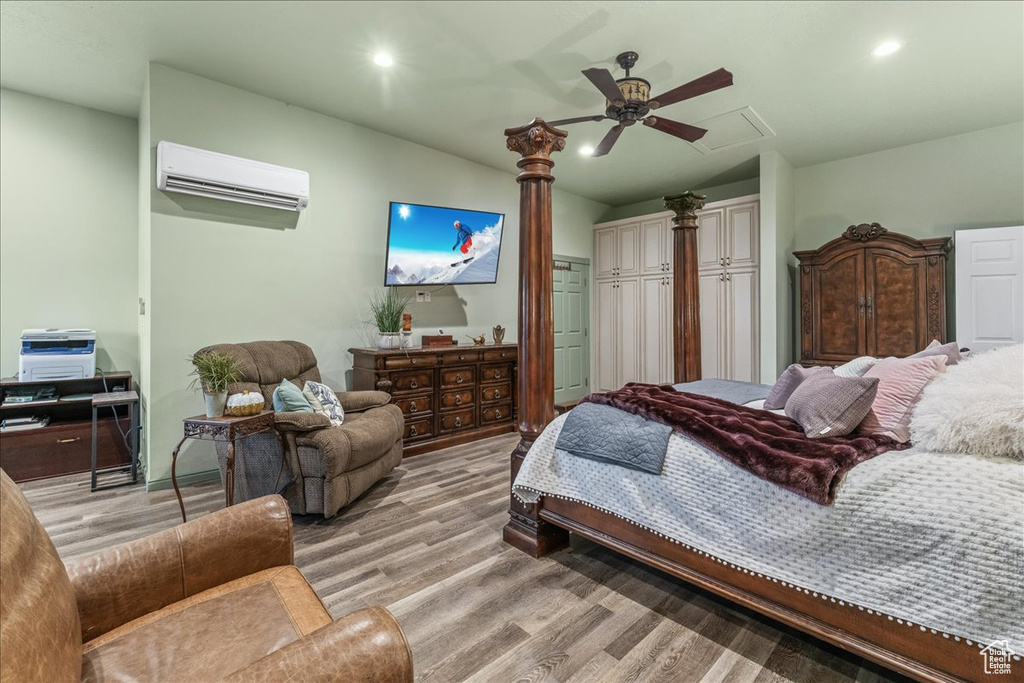 Bedroom featuring light wood-type flooring, a wall mounted AC, and ceiling fan