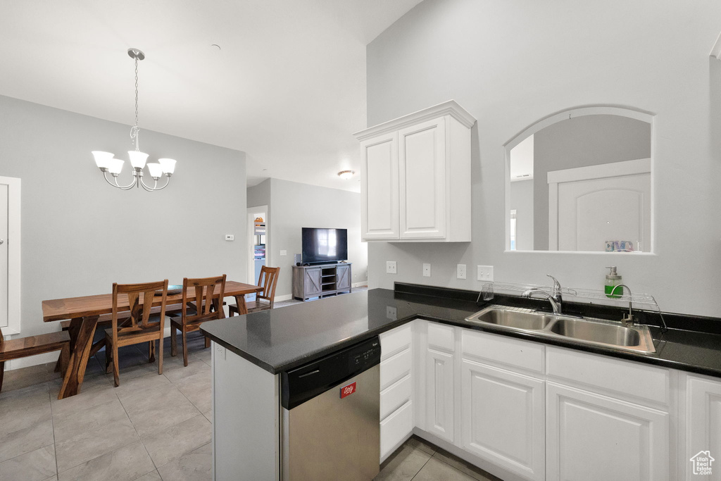 Kitchen with light tile flooring, stainless steel dishwasher, an inviting chandelier, and sink