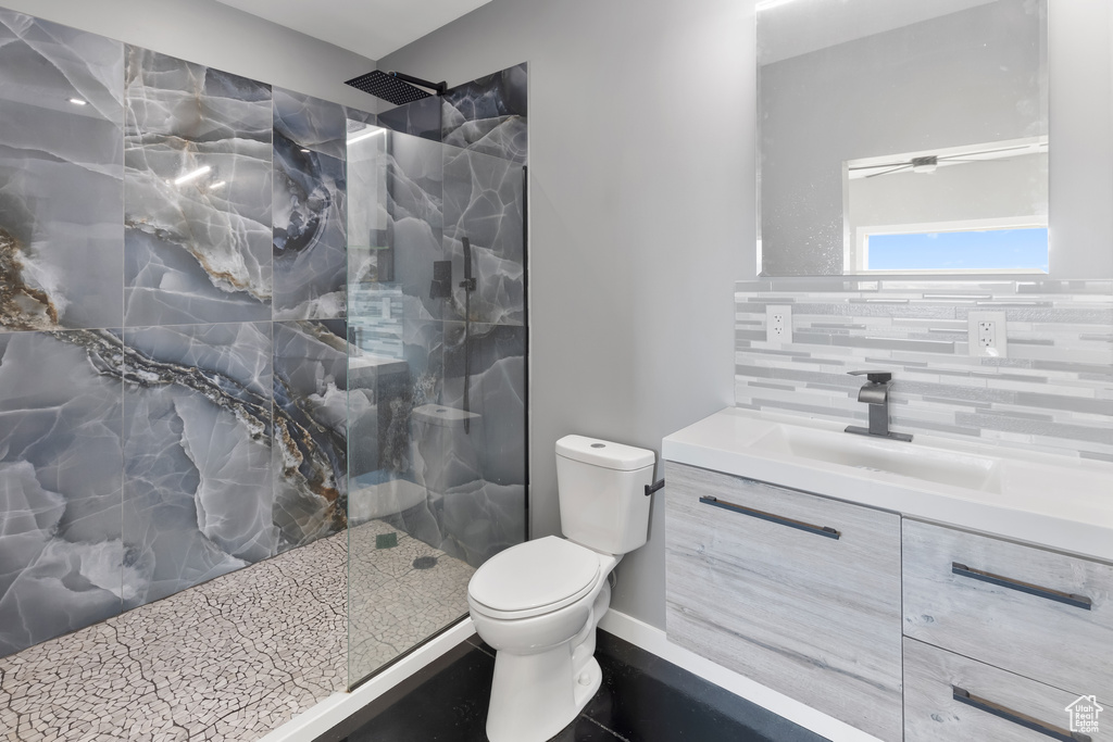 Bathroom featuring vanity, tasteful backsplash, an enclosed shower, tile walls, and toilet