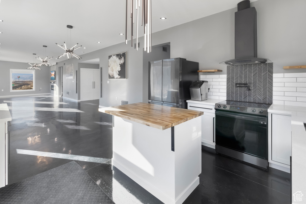 Kitchen featuring a chandelier, stainless steel appliances, white cabinets, and tasteful backsplash
