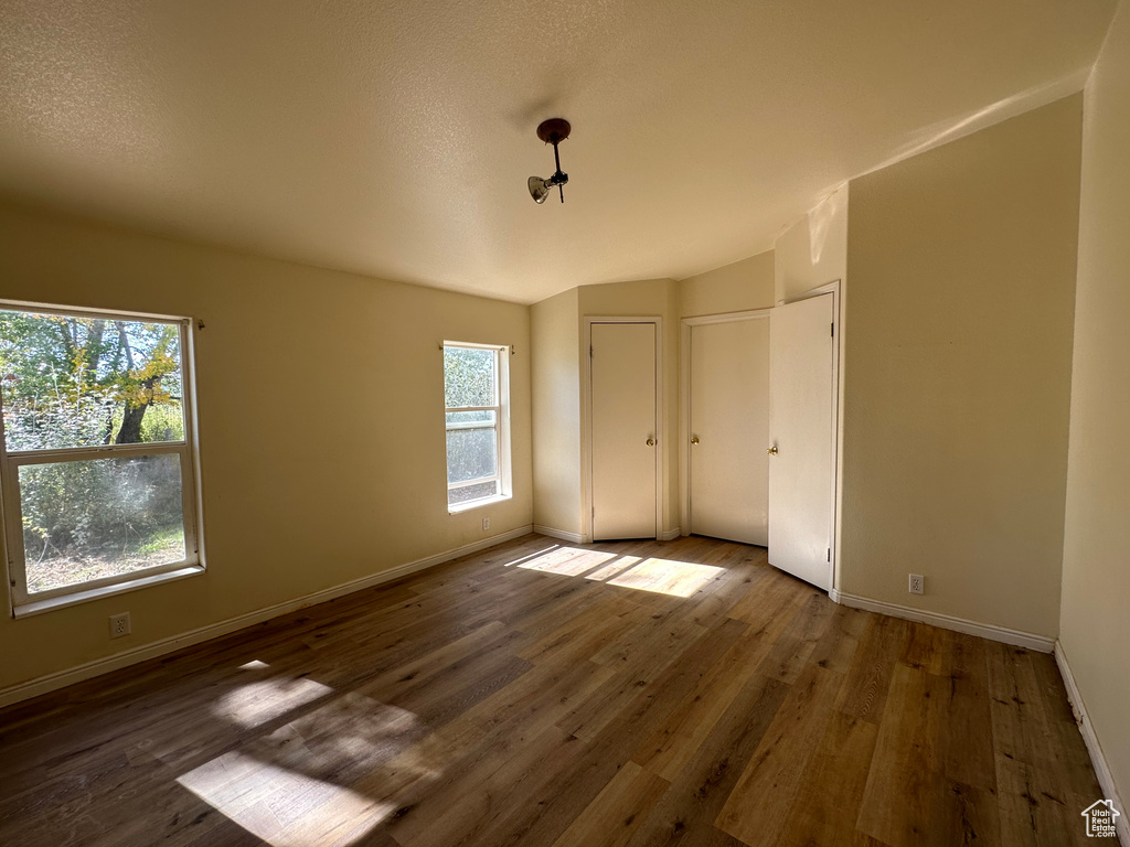 Spare room featuring a wealth of natural light and dark hardwood / wood-style floors