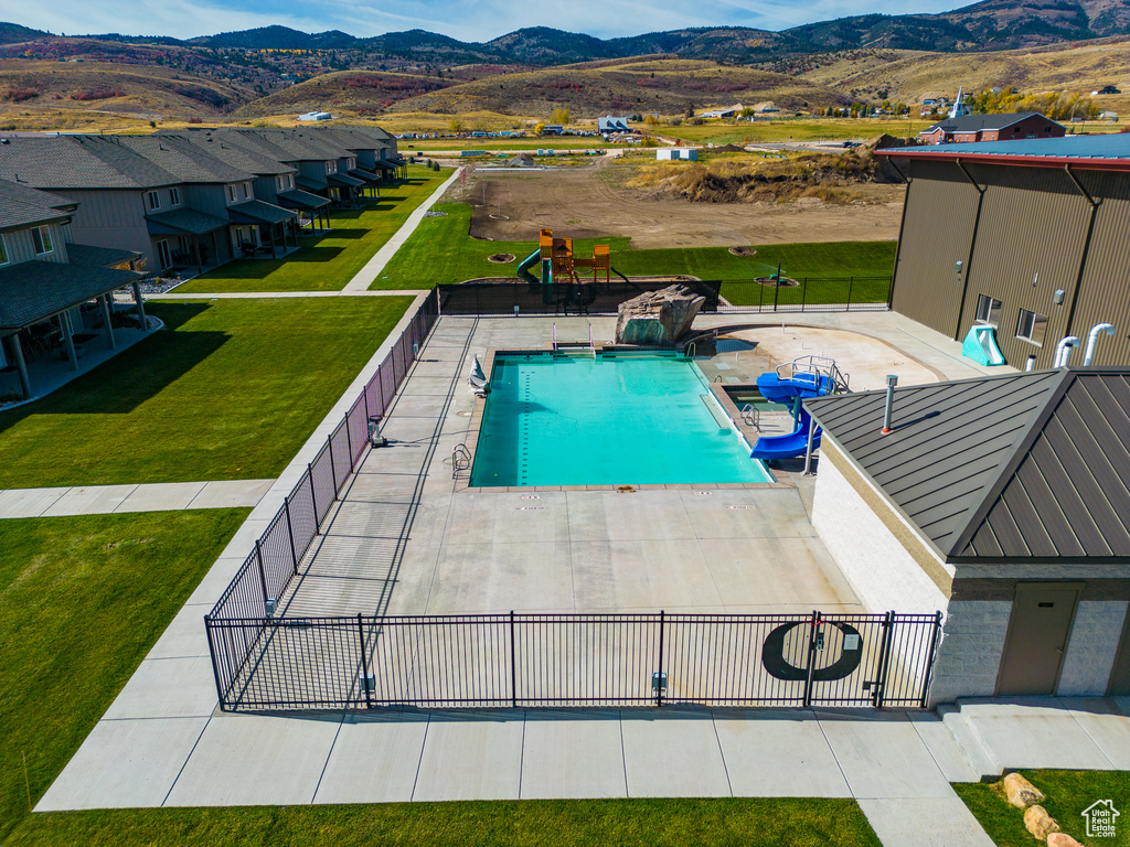 View of pool featuring a mountain view, a yard, and a patio area