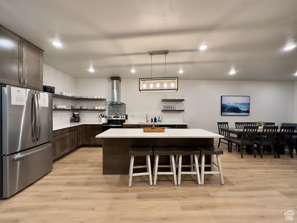 Kitchen featuring light wood-type flooring, appliances with stainless steel finishes, and a center island