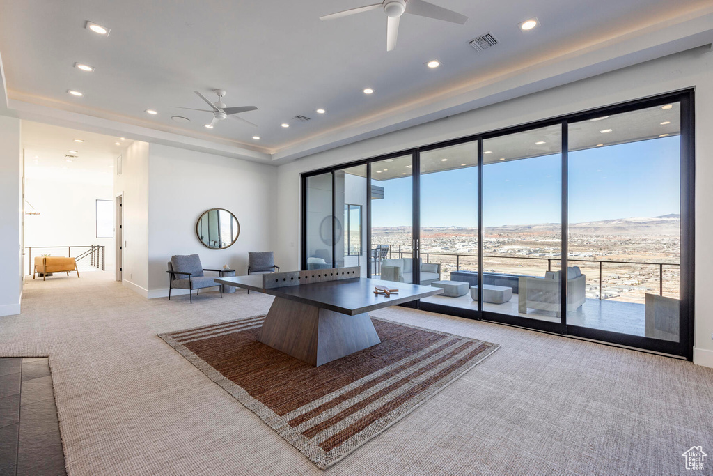 Living room with light carpet, a healthy amount of sunlight, and ceiling fan