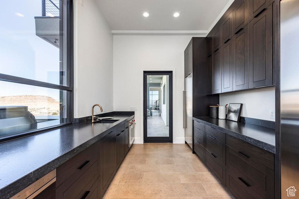 Kitchen featuring sink, a wealth of natural light, light tile patterned floors, and oven