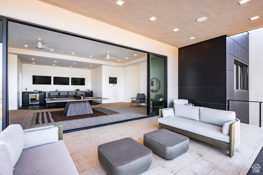 Living room featuring a tray ceiling and ceiling fan