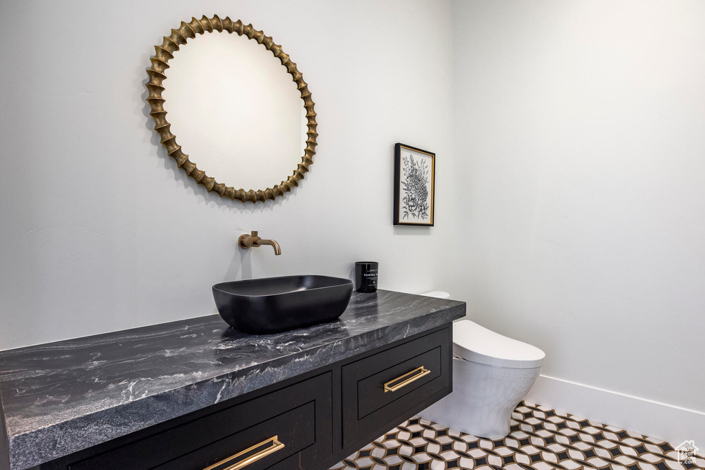 Bathroom featuring vanity, toilet, and tile patterned floors