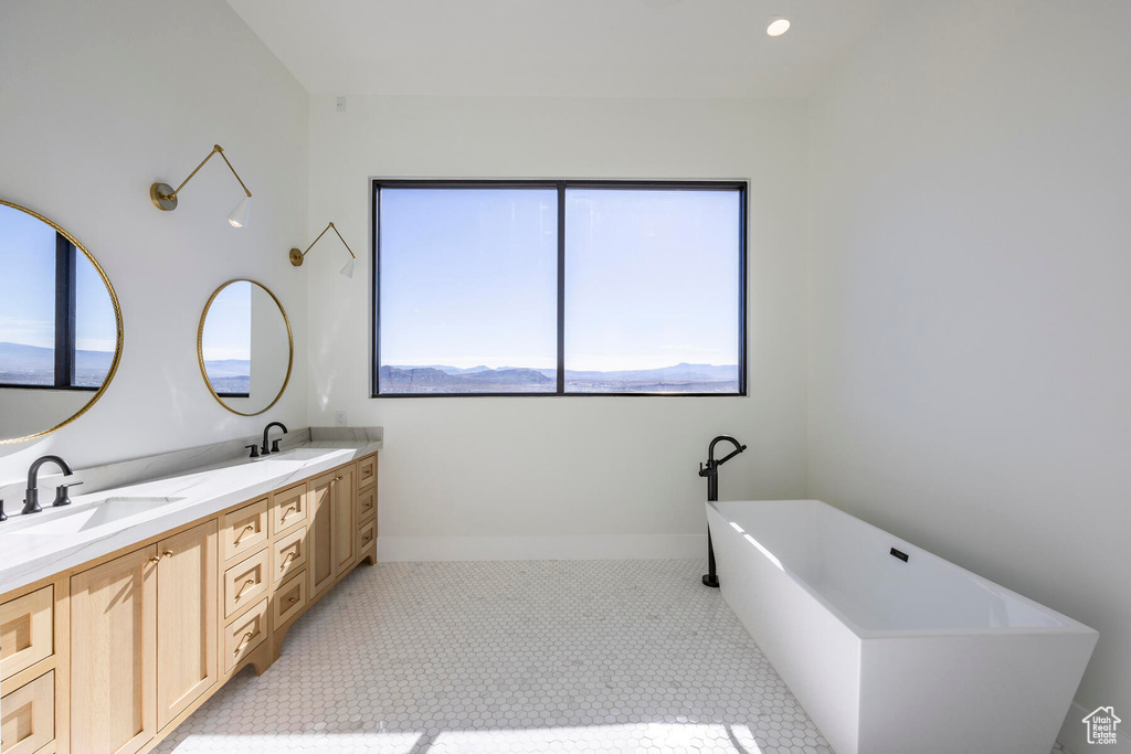 Bathroom featuring tile patterned flooring, dual vanity, a bath, and plenty of natural light