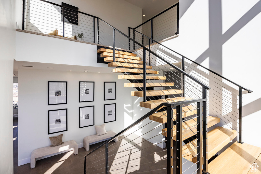 Stairway featuring hardwood / wood-style floors and a high ceiling