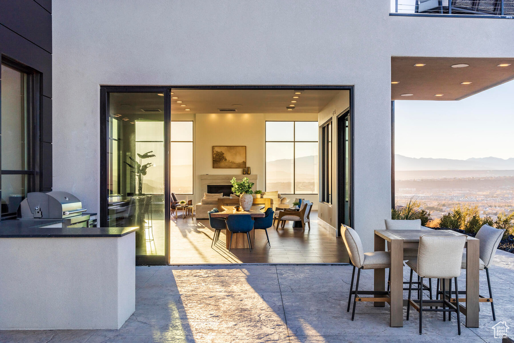 Patio terrace at dusk featuring a mountain view and grilling area