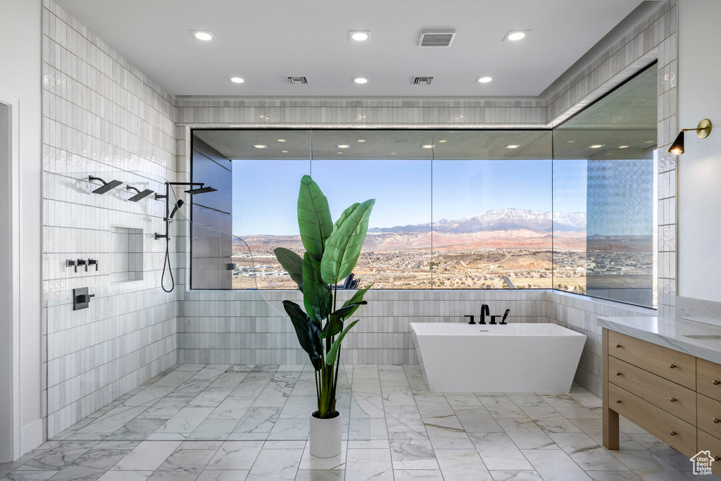 Bathroom with tile patterned flooring, tile walls, and a shower