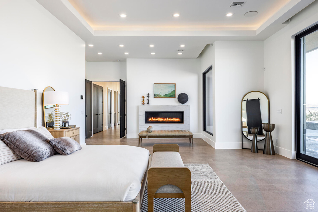 Bedroom featuring access to outside and a raised ceiling