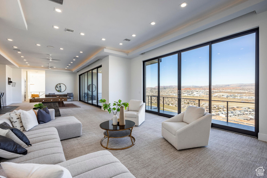 Carpeted living room featuring ceiling fan