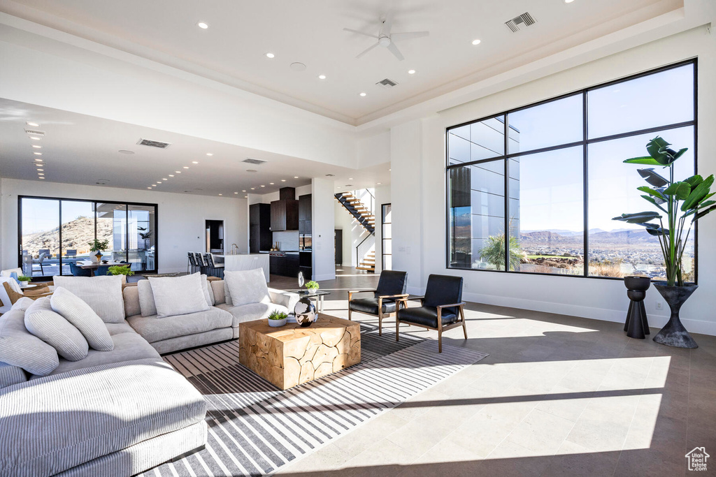 Living room with ceiling fan, a mountain view, and a raised ceiling