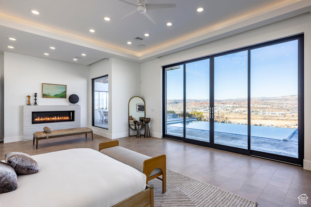 Bedroom featuring tile patterned flooring, a water view, access to exterior, and ceiling fan