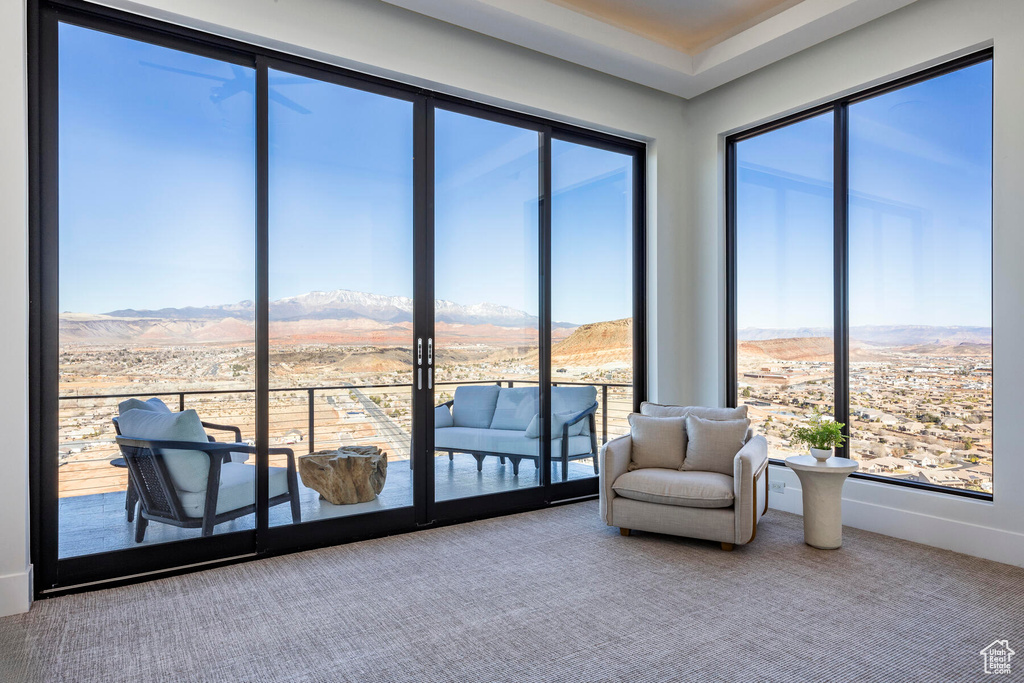 Unfurnished room with carpet flooring, a healthy amount of sunlight, and a mountain view