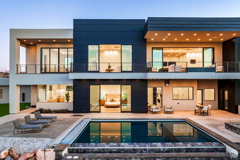 Back of house with a patio and a balcony