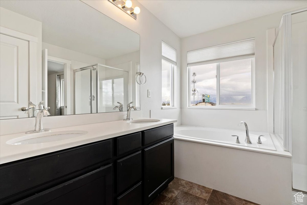 Bathroom with plenty of natural light, double sink vanity, independent shower and bath, and tile flooring