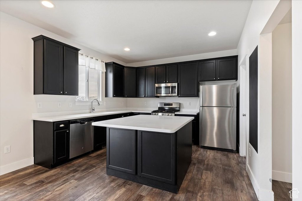 Kitchen featuring dark hardwood / wood-style flooring, sink, a kitchen island, and stainless steel appliances