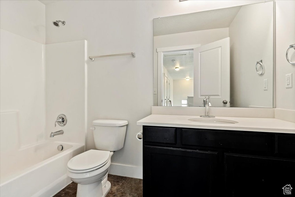 Full bathroom featuring vanity, toilet, tile floors, and tub / shower combination