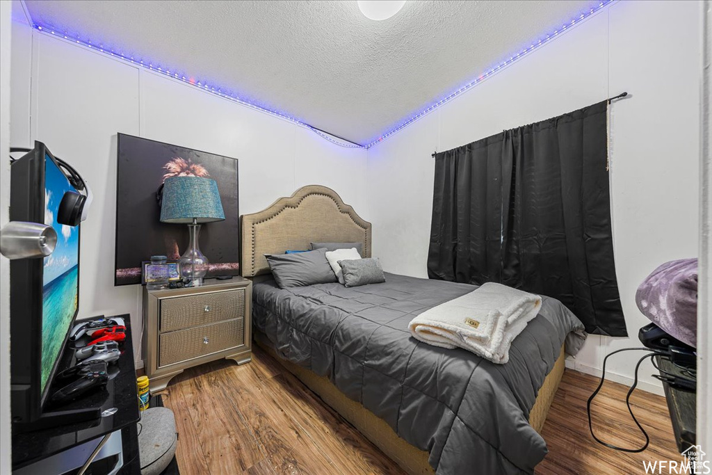 Bedroom with a textured ceiling and hardwood / wood-style flooring