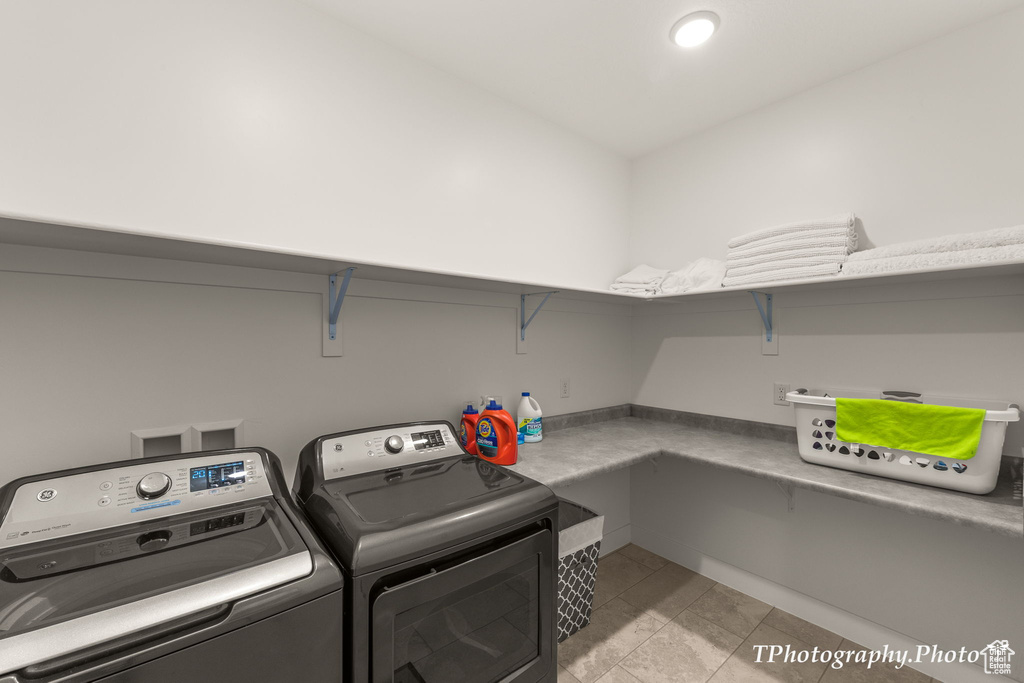 Washroom with light tile flooring, washer and clothes dryer, and hookup for a washing machine