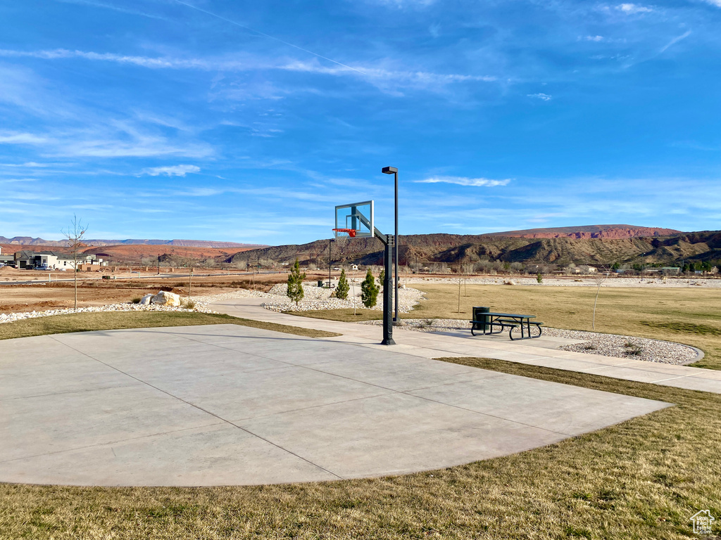 Exterior space with a yard, basketball hoop, and a mountain view