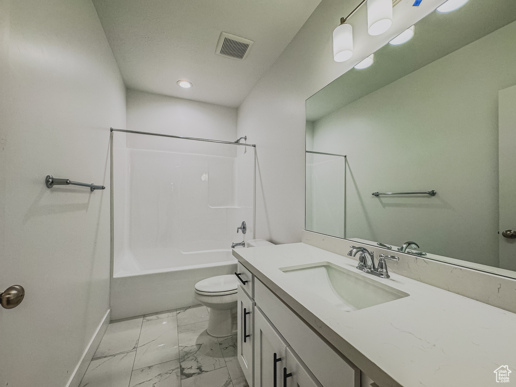 Full bathroom with toilet, shower / bathtub combination, tile floors, and vanity with extensive cabinet space