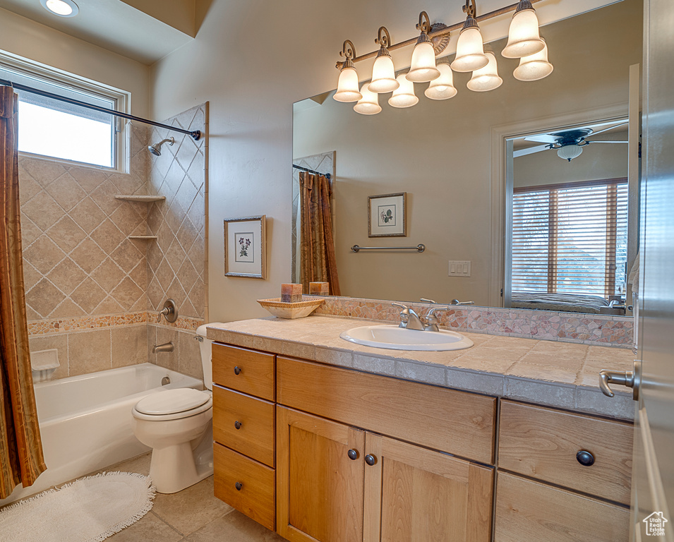Full bathroom featuring oversized vanity, toilet, shower / bathtub combination with curtain, tile flooring, and ceiling fan