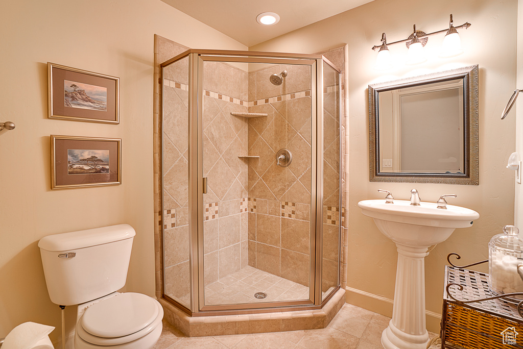 Bathroom featuring a shower with shower door, tile floors, and toilet