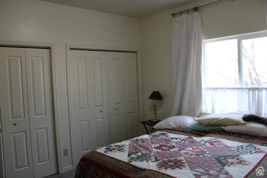 Bedroom featuring multiple closets and multiple windows