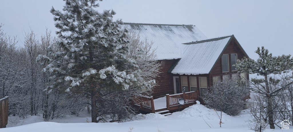 View of snow covered exterior with a deck