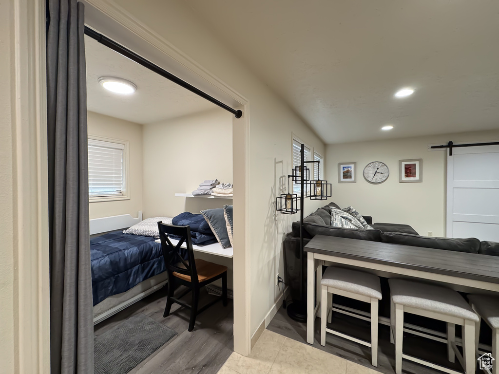 Bedroom featuring light hardwood / wood-style floors and a barn door
