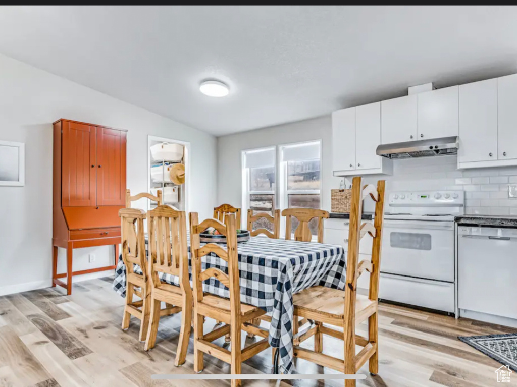 Kitchen with white cabinets, backsplash, white appliances, light hardwood / wood-style flooring, and lofted ceiling