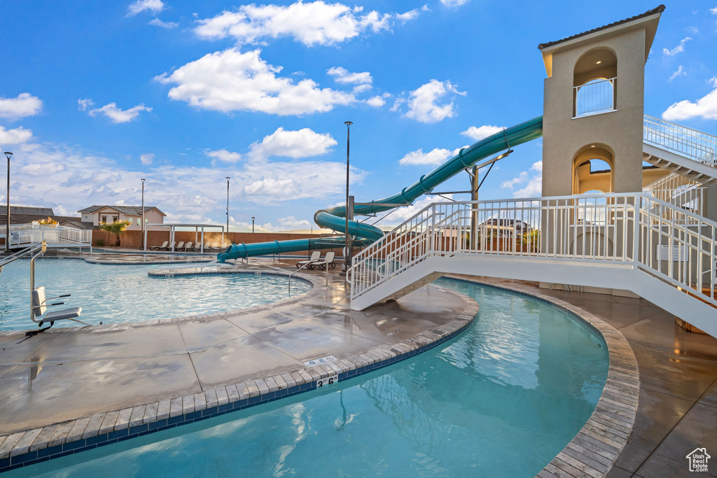 View of pool with a water slide and a patio