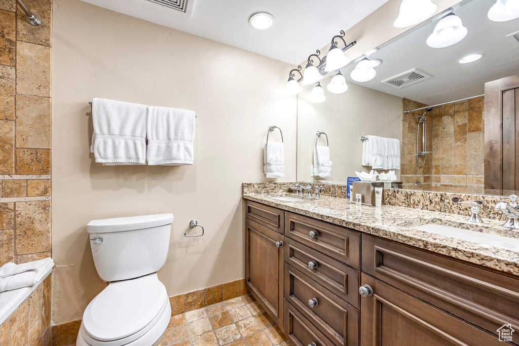 Bathroom featuring dual vanity, tile flooring, and toilet