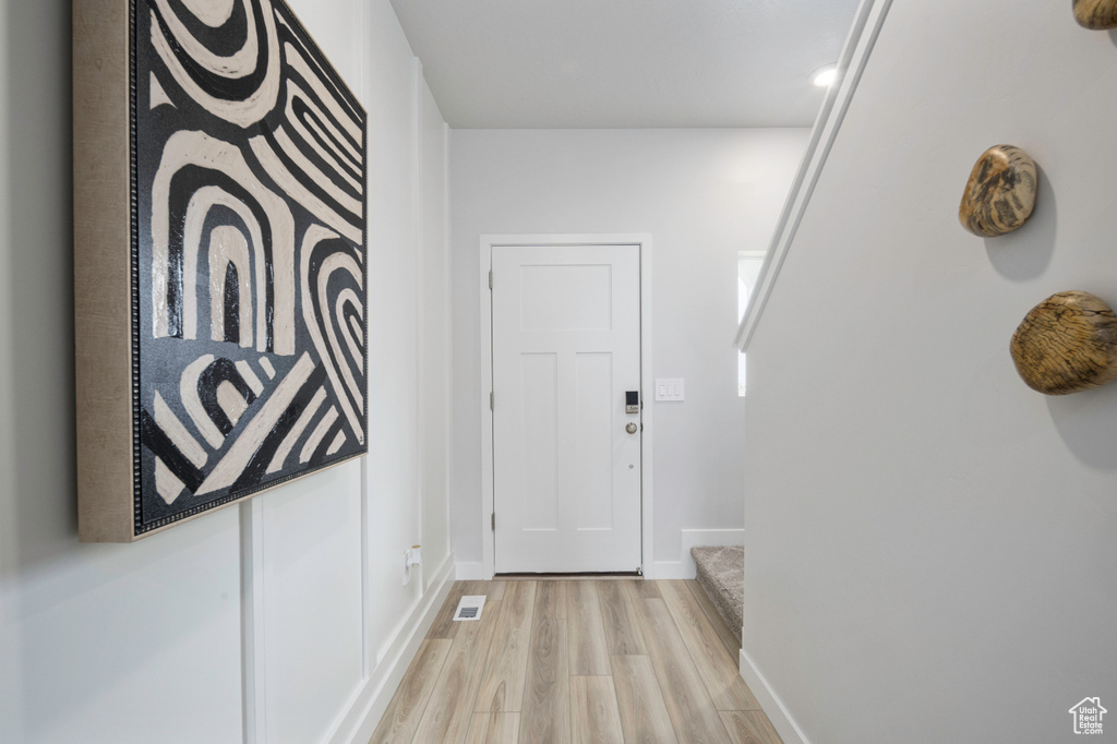 Doorway with light hardwood / wood-style flooring