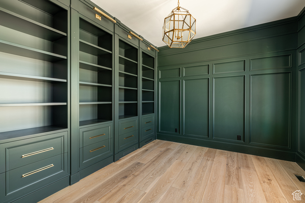 Spacious closet with light hardwood / wood-style flooring